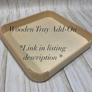 May include: A square wooden tray with rounded corners and a light wood finish. The tray has a recessed interior and the text "Wooden Tray Add-On" and "*Link in listing description*" is printed on the tray.