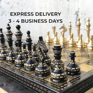 May include: A chess set featuring black pieces with gold-coloured etched horizontal lines and metallic gold-coloured pieces. The board has a black and gold-coloured grid pattern. Text on the image reads: EXPRESS DELIVERY 3 - 4 BUSINESS DAYS.