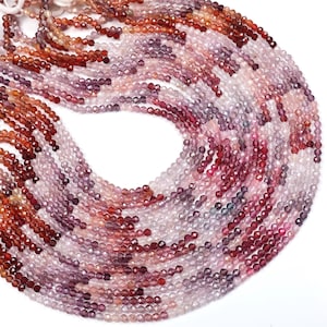 May include: A strand of pink, red, and purple gemstone beads. The beads are faceted and have a slightly irregular shape. The strand is approximately 16 inches long.