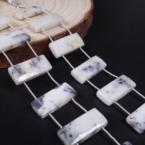 May include: A strand of white and black dendritic agate beads, each bead is rectangular and strung on a silver wire.