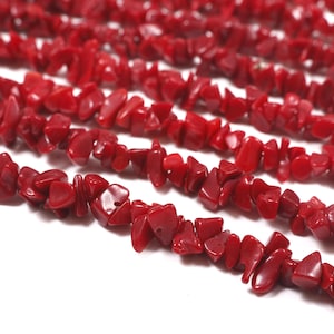 Puede incluir: Primer plano de varios hilos de cuentas de coral rojo. Las cuentas tienen forma irregular y un acabado pulido y brillante. El color rojo vibrante es consistente en todos los hilos, creando una textura visualmente atractiva. Ideal para la fabricación de joyas.