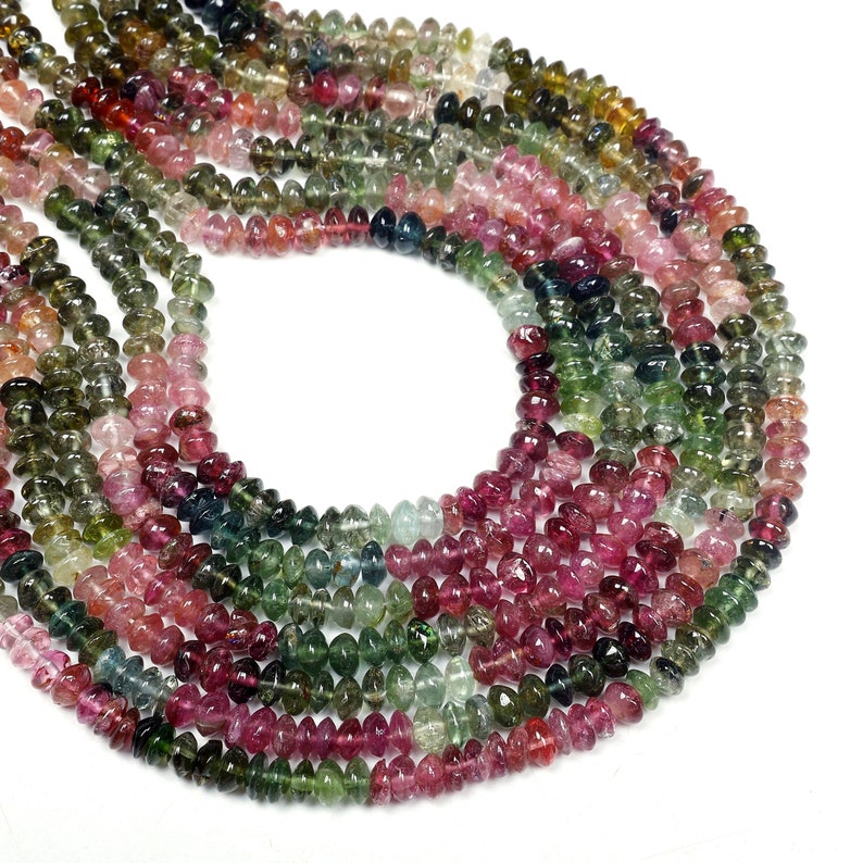 May include: A strand of multi-colored tourmaline beads. The beads are faceted and have a smooth, polished finish. The colors of the beads include pink, green, and blue.