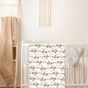May include: A white cot sheet with a floral pattern and the names "Mila Grace" repeated throughout. The sheet is in a nursery setting with a wooden ladder and a macrame dream catcher.