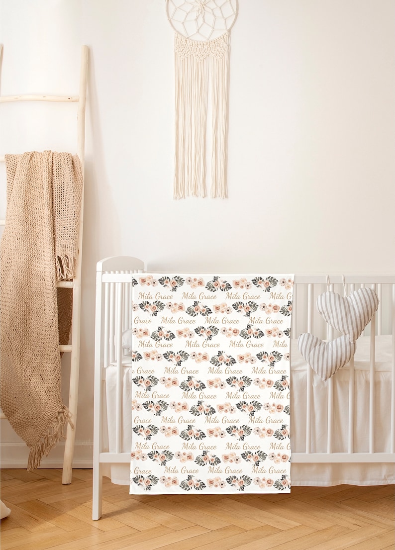 May include: A white cot sheet with a floral pattern and the names "Mila Grace" repeated throughout. The sheet is in a nursery setting with a wooden ladder and a macrame dream catcher.