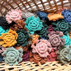 May include: A wicker basket filled with colorful handmade macrame coasters. The coasters are circular and feature a variety of colors, including pink, blue, green, yellow, and brown.