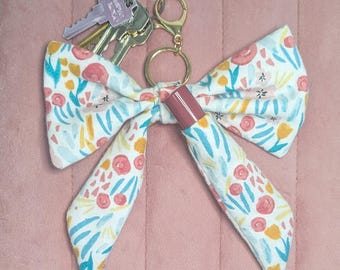 Llavero porta bálsamo labial con lazo de tela: Bolsa de bálsamo labial con diseño floral