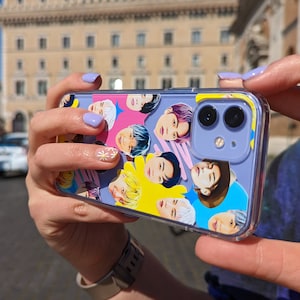 May include: A purple iPhone case with a clear back and a colourful design featuring multiple faces of people. The case has a dual camera lens.