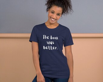 Pode incluir: Uma camiseta azul marinho com texto branco que diz "The book was better."