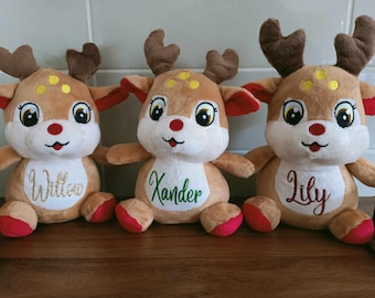 May include: Three soft toy reindeer with brown fur, large eyes, and red details. Each reindeer has a name embroidered on its chest: Willow, Xander, and Lily. They have brown antlers and red hooves, ideal for Christmas presents.