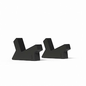 May include: Two black, angular objects with a V-shaped design. The objects are symmetrical and appear to be made of a solid material. They are set against a plain white background.