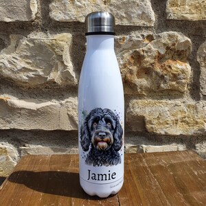 May include: White stainless steel water bottle featuring a black and white watercolour illustration of a dog with the name "Jamie" printed on the bottle.