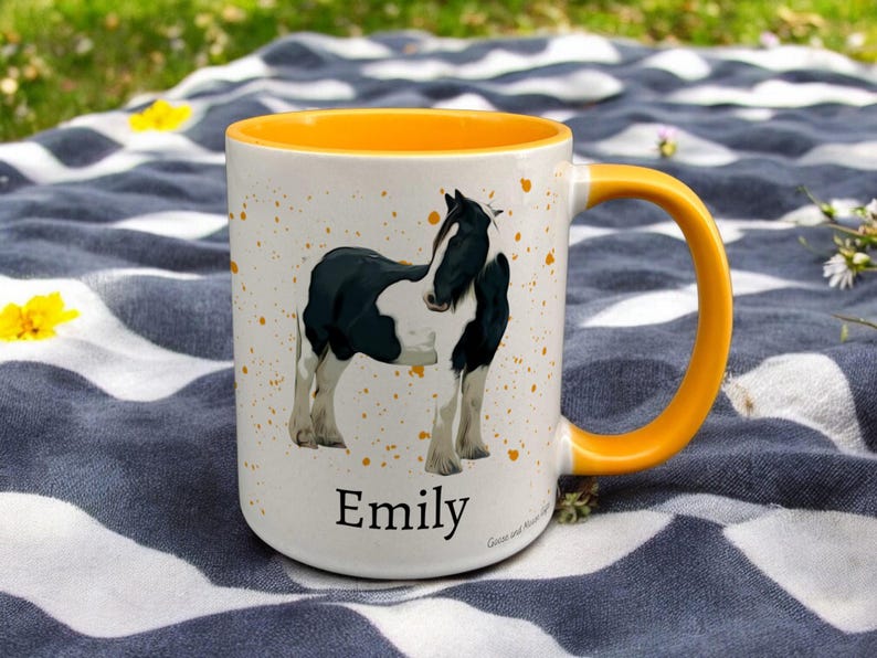 yellow & White Ceramic Mug with Horse Design sat on a table. The Cup has a standard handle. Customisable text is printed below the Horse design in a black text.