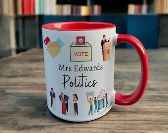 May include: White ceramic mug with a red rim and handle. The mug has a design of people voting, a ballot box, and the text "Mrs Edwards Politics".