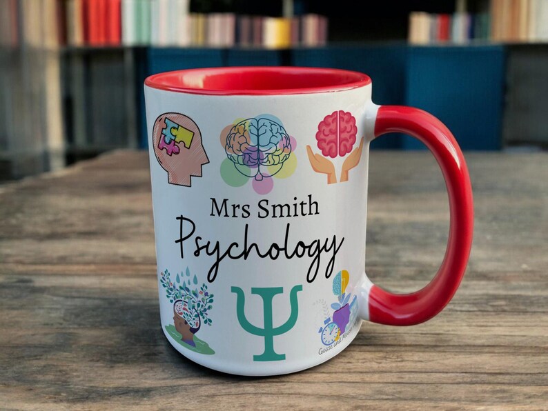 Red & White Ceramic Mug with Psychology Design sat on a table. The Cup has a standard handle. Customisable text is printed below the Psychology design in a black text.