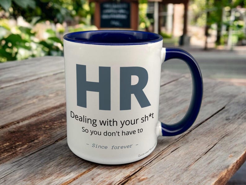Navy & White Ceramic Mug with HR Design sat on a table. The Cup has a standard handle.