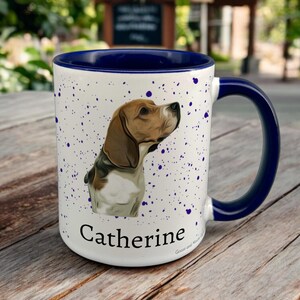 May include: White ceramic mug with a navy blue interior and handle. The mug features a beagle illustration and the name "Catherine" in a script font. The mug has a speckled design with navy blue splatters.