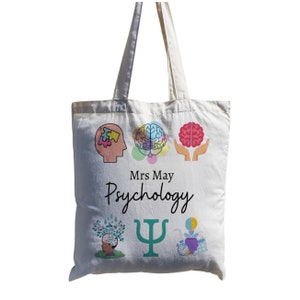 Puede incluir: Una bolsa de lona blanca con un dise&ntilde;o colorido que presenta un cerebro, una pieza de rompecabezas, una mano sosteniendo un cerebro, un &aacute;rbol, una letra griega psi y una bombilla. El texto "Mrs May Psychology" est&aacute; impreso en la bolsa.
