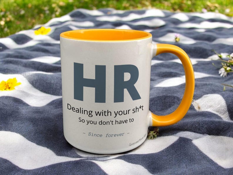 Yellow & White Ceramic Mug with HR Design sat on a table. The Cup has a standard handle.