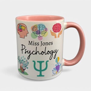 May include: White ceramic mug with a pink rim and handle. The mug has a design of colorful brain illustrations, the text "Miss Jones Psychology", and a green Greek letter Psi.