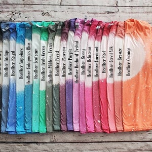 May include: A row of 20 t-shirts in various heather colors, including dark heather, navy, indigo, royal, sapphire, Galapagos blue, seafoam, Irish green, military green, forest, maroon, purple, radiant orchid, berry, heliconia, cardinal, red, coral silk, bronze, and orange.
