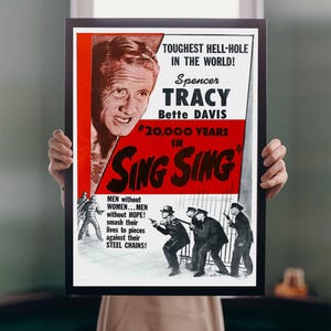 May include: A framed vintage movie poster for "20,000 Years in Sing Sing" featuring Spencer Tracy and Bette Davis. The poster has a red and black colour scheme with text that reads "Toughest Hell-Hole in the World!"