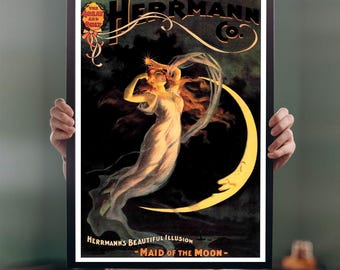 May include: A framed vintage poster featuring a woman in a flowing gown with long red hair, standing on a crescent moon. The poster has the text "HERRMANN CO." and "MAID OF THE MOON". The color palette includes black, yellow, and cream.