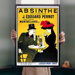 Puede incluir: Un anuncio vintage enmarcado de Absenta, con el texto "ABSINTHE EXTRA-SUPERIEURE J. ÉDOUARD PERNOT MONTBELIARD". El póster representa a un hombre y una mujer en una mesa, con botellas y una copa. La mujer lleva un sombrero rojo.