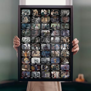 May include: A rectangular black-framed wall art piece featuring a grid of numerous small, individual television screen images. Each screen displays a different scene from various films, arranged in rows and columns within the dark frame.