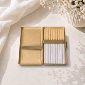Open gold cigarette case with cigarettes inside slim metal holder