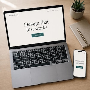 May include: A silver laptop and a smartphone displaying a website for Lumen & Co. with the text Design that just works and a Get Started button. The screen shows a navigation menu with Work, About, and Contact links on a light background.