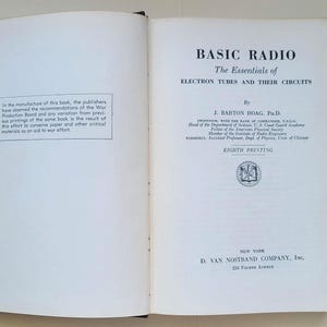 May include: Open book titled "BASIC RADIO" with text about electron tubes and circuits. The book's cover includes the author's name, J. Barton Hoag, and mentions the eighth printing. A note on the left page discusses wartime paper conservation.