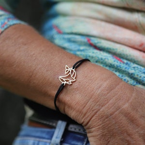 Può includere: Un braccialetto in corda nera con un ciondolo d'argento a forma di mezzaluna con un design a foglia stilizzato.