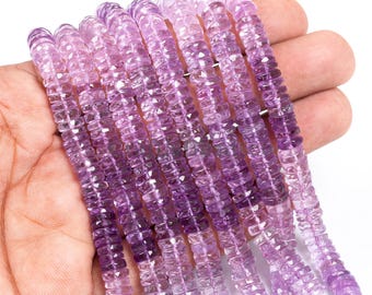 May include: Strands of amethyst gemstone beads in varying shades of purple and lavender. The beads are rectangular and faceted, creating a sparkling effect. The beads are held in a hand, showcasing their color and texture. Ideal for jewelry making.