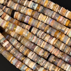 Könnte beinhalten: Eine Strähne aus mehrfarbigen Opalperlen. Die Perlen sind facettiert und haben verschiedene Formen und Größen. Die Perlen sind auf einem durchsichtigen Faden aufgefädelt.