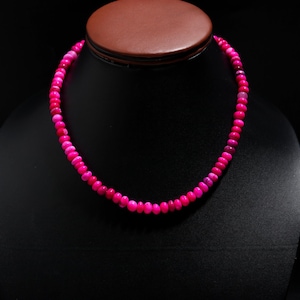 Puede incluir: Un collar de cuentas de piedras preciosas rosas. Las cuentas son redondas y tienen una ligera variación de color.