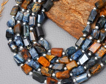 May include: A multi-strand necklace featuring faceted gemstone beads in shades of blue, brown, and black. The beads are strung together with small silver-colored spacer beads. The necklace is displayed on a gray surface.
