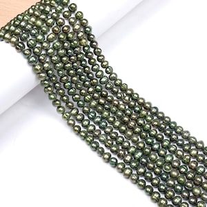 Peut inclure: Un brin de perles d'eau douce vertes. Les perles sont rondes et ont un léger éclat iridescent.