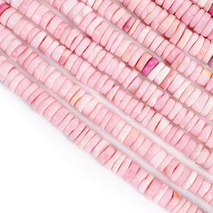 May include: Close-up of strands of pink gemstone beads. The beads are flat, disc-shaped, and have a slightly irregular texture. The color varies from pale to medium pink, with some beads showing a deeper rose hue. The beads are strung together, creating a textured surface.