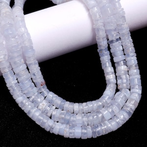 May include: A strand of light blue gemstone beads. The beads are faceted and have a slightly irregular shape. The beads are strung on a clear thread.