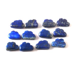 Peut inclure: Douze pierres en forme de nuage en lapis-lazuli bleu. Les pierres sont polies et ont un aspect brillant et scintillant.