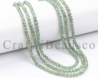 May include: Three strands of green faceted gemstone beads. The beads are small and round, and they are strung on a clear thread. The beads are arranged in a loose, flowing pattern.