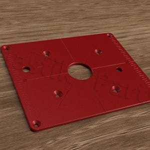 May include: Red plastic jig with a large centre hole and multiple smaller holes for drilling. The jig has a ruler on the side.