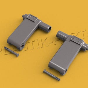 Könnte beinhalten: Zwei graue Kunststoff-Türgriffe mit einem kleinen Metallstift. Die Griffe sind rechteckig mit einem kleinen rechteckigen Knopf oben.