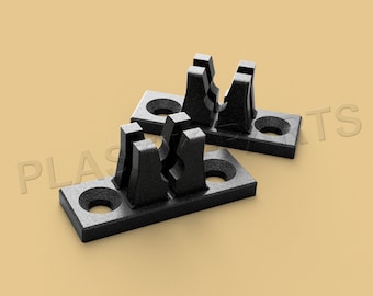 May include: Two black plastic clips with a rectangular base and two vertical prongs. The clips are designed to hold items in place.