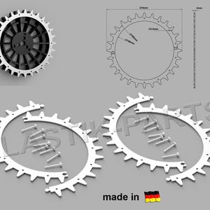 Puede incluir: Dos anillos de engranaje de plástico blanco, cada uno con 21 dientes, diseñados para encajar entre sí y formar una rueda de engranaje completa. Los anillos se muestran con tornillos para el montaje. La imagen también muestra una rueda de engranaje negra con 21 dientes y un diagrama de la rueda de engranaje con dimensiones en milímetros.