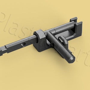 Puede incluir: Un pestillo de plástico negro con un brazo largo y recto y un brazo más corto y angulado. El pestillo está diseñado para asegurar dos piezas de material juntas.