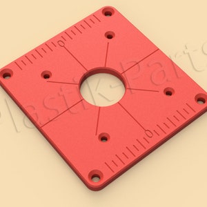 May include: Red plastic square template with a large center hole and smaller holes around the perimeter. The template has a ruler on two sides.