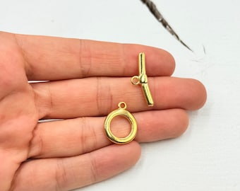 May include: Gold-toned metal toggle clasp with a round ring. The clasp is designed for jewelry making and is a popular choice for necklaces and bracelets.
