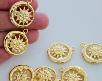May include: A collection of gold-toned metal charms featuring a sun and moon design. The charms are round and have a detailed design of a sun with a face and a crescent moon.