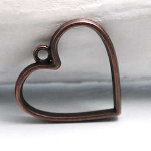 May include: A copper-colored metal heart-shaped pendant with a loop at the top for hanging.